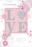 In this image, an anniversary card unfolds like a quiet love story, its design as gentle and romantic as a pastel bouquet prepared for delivery across Dollis Hill. At the centre, the word LOVE is spelled out in soft, raised glitter, the edges shimmering in silver so that the letters seem to glow against the blush-pink background. The letter forms are broad and inviting, almost sculptural to the touch, with the overall texture suggesting the feel of embossed petals. Surrounding this focal point, delicate blooms painted in blush and mauve unfurl with a watercolor softness, their petals outlined in fine, flowing lines that curl into graceful vines. Subtle details-tiny petals, swirling flourishes, and small, almost hidden butterflies-give the impression of movement, like a garden path you might stroll along after walking back from Gladstone Park. Hints of silvery grey and pearly white add an air of refinement, echoing the understated elegance often requested for anniversary flowers in local homes. The text On Our Anniversary and I love you today and always appears in a graceful, understated script, carefully positioned so it feels part of the floral composition rather than simply printed on top. Overall, the card radiates a feeling of treasured intimacy-soft as a whispered promise, yet deeply heartfelt-perfect for marking another year together in Dollis Hill, surrounded by familiar streets and shared memories.